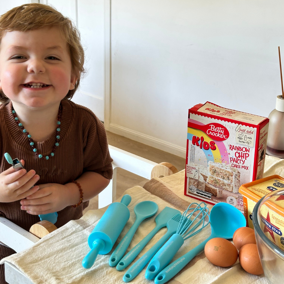 Toddler laughing happily while preparing to cook
