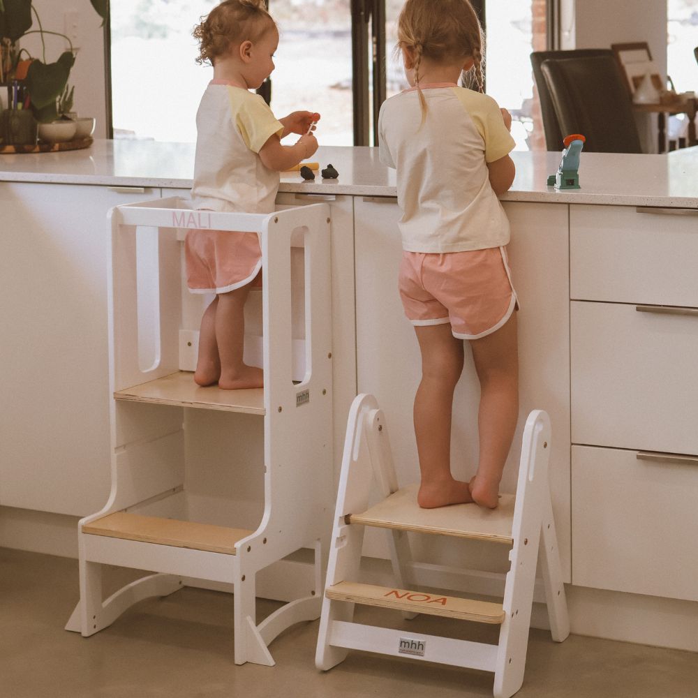 toddler and baby in kitchen with step stool