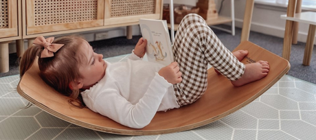 child laying in balance board