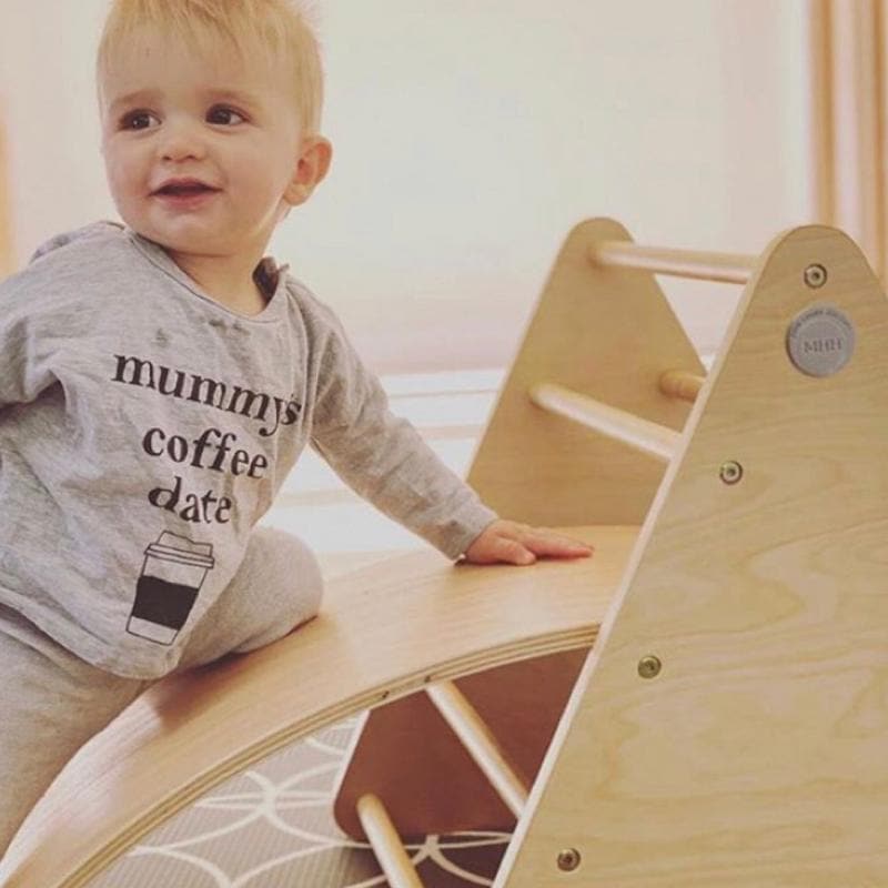 Young child exploring baby climbing frame