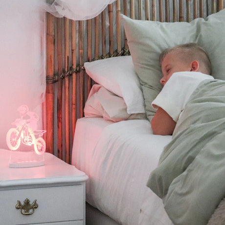 Motorbike night light glowing on a bedside table