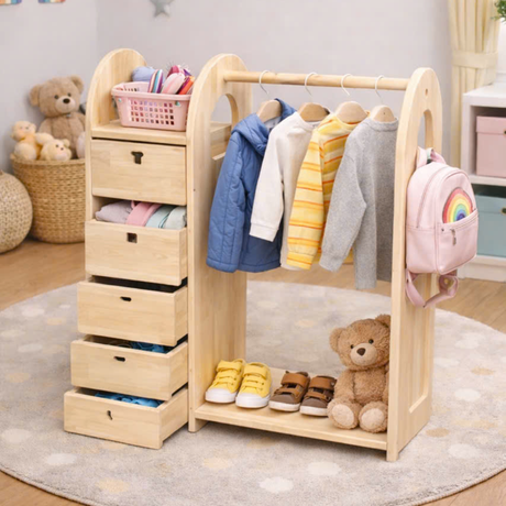 Montessori wooden wardrobe with clothes, shoes, and a backpack in a room setting.
