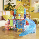 Magnetic toy house with a slide on a wooden floor in a room with furniture and decor.