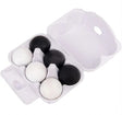A white styrofoam egg carton holding six eggs, four black and two white, photographed on a plain white background.